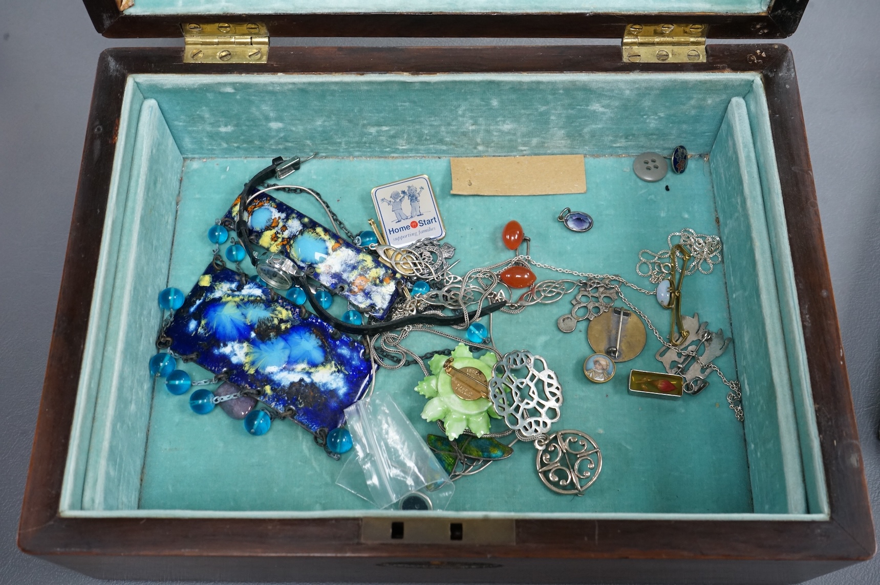 Assorted costume and other jewellery including a cased pair of paste buckles, agate set fob seal, a9ct pendant on a 9ct gold chain, Egyptian white metal bangle, a Scottish silver pendant, etc, housed in a mahogany work b